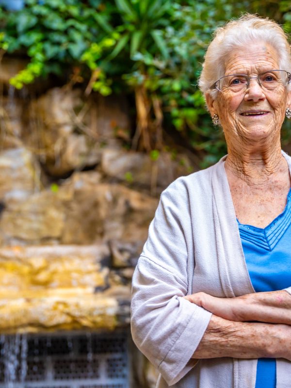 Smiling elder woman looking at camera and smiling in the garden of a nursing home